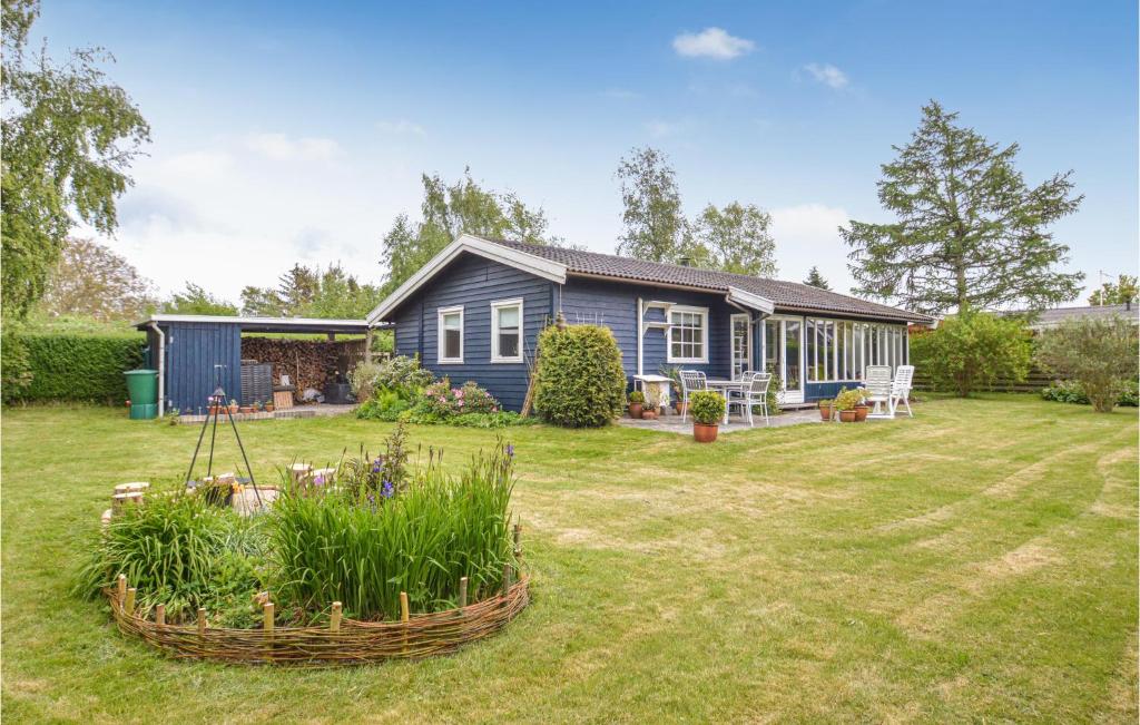 a blue house with a garden in the yard at Amazing Home In Stubbekbing With Kitchen in Stubbekøbing