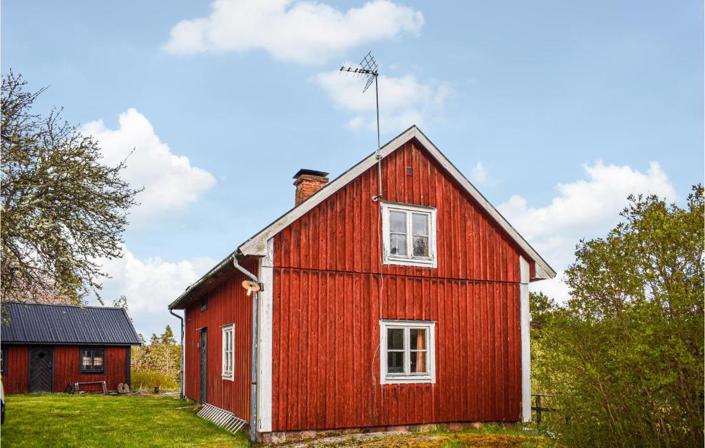une maison rouge avec des fenêtres blanches sur un champ vert dans l'établissement Awesome Home In deshg With House A Panoramic View, à Ödeshög