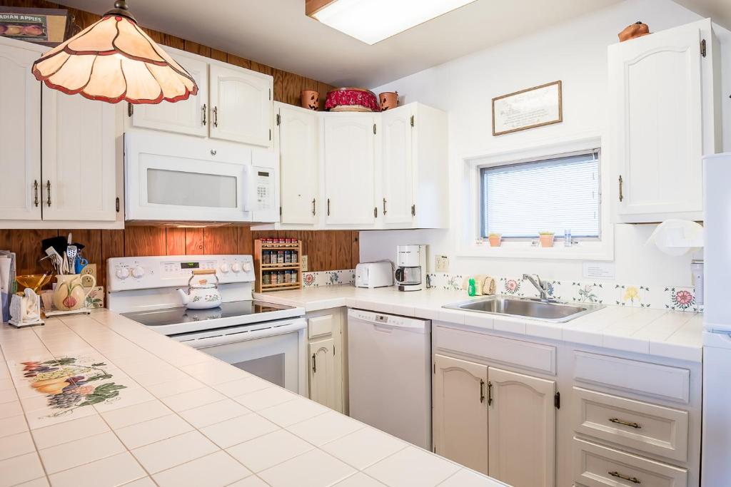 una cocina con armarios blancos y fregadero en Alpine Villa 21 - Perfect for a Couple or Family of Four Walk to Lifts & Town, en Ketchum