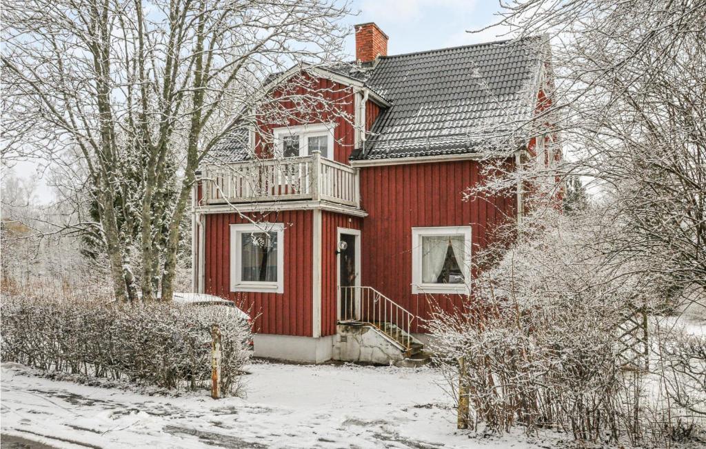 a red house with a balcony in the snow at Beautiful Home In Filipstad With Kitchen in Filipstad