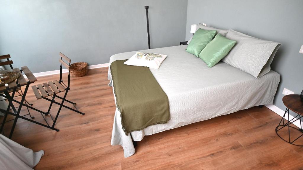 a bedroom with a bed with green and white pillows at L'Iris B&B in Terrazza in Lucca