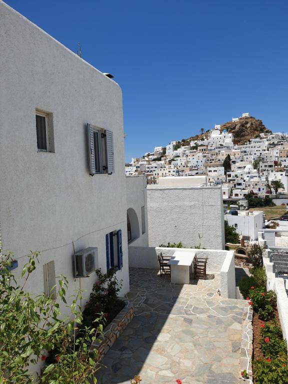 a white building with a walkway in front at Aphrodite Hotel & Apartments in Ios Chora