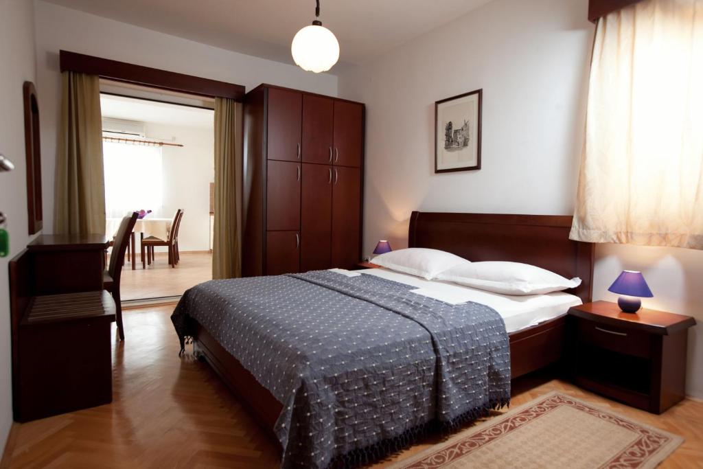 a bedroom with a bed and a dining room at Agava Apartments Begic in Makarska