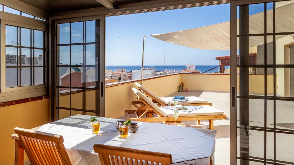 een balkon met 2 tafels en uitzicht op de oceaan bij Maxorata in Morro del Jable