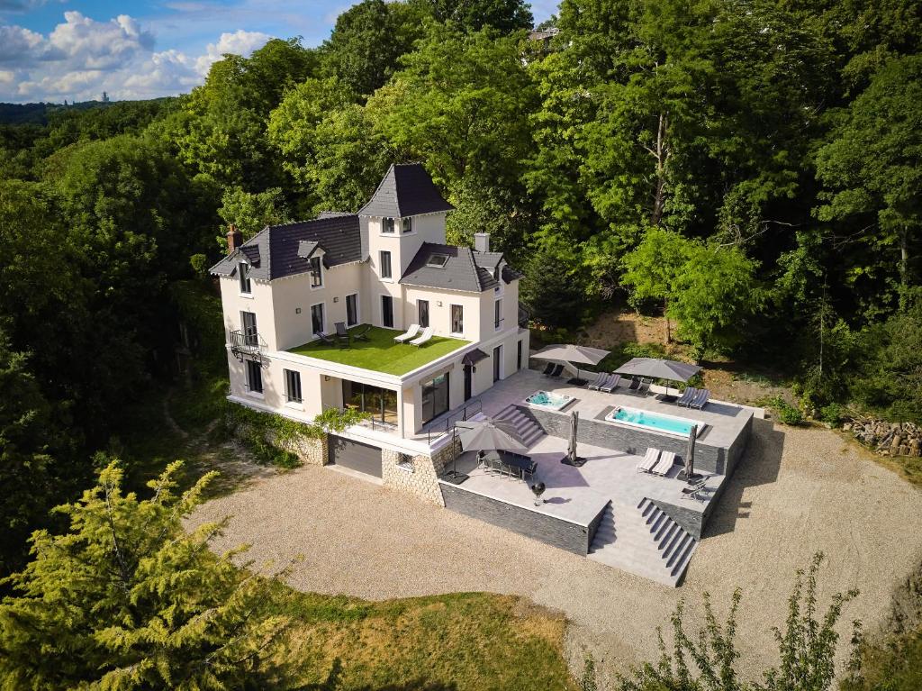  Elle offre une vue aérienne sur une grande maison blanche dotée d'une piscine. dans l'établissement LA VILLA AUBIN belle demeure avec vue sur Paris, à Montmorency