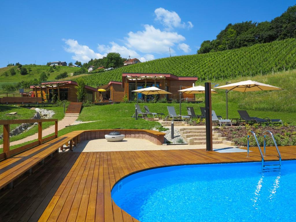 una piscina en una terraza de madera junto a una casa en Naturasort Holiday Houses en Pesnica pri Mariboru