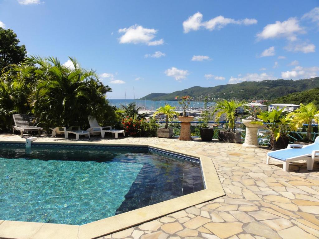 a swimming pool with a view of the water at Résidence des îles in Le Marin
