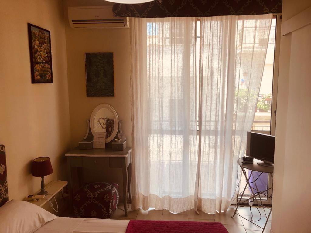 a bedroom with a bed and a window with curtains at All My Home in Villa San Giovanni