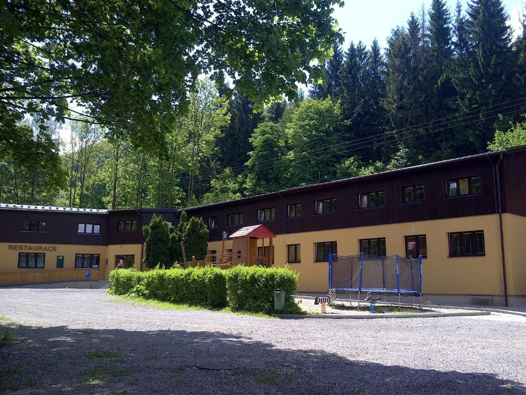 un grupo de edificios con árboles en el fondo en Penzion Zátiší, en Komorní Lhotka