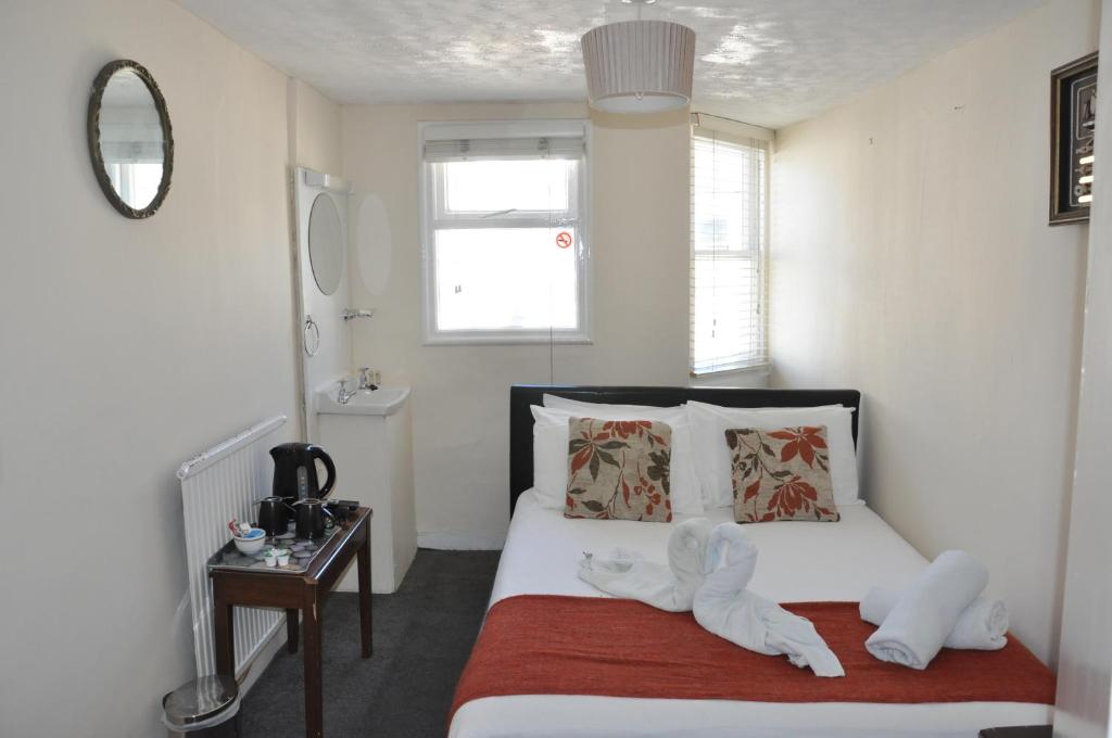 a bedroom with a bed with stuffed animals on it at Relax Inn Guest House in Brighton & Hove