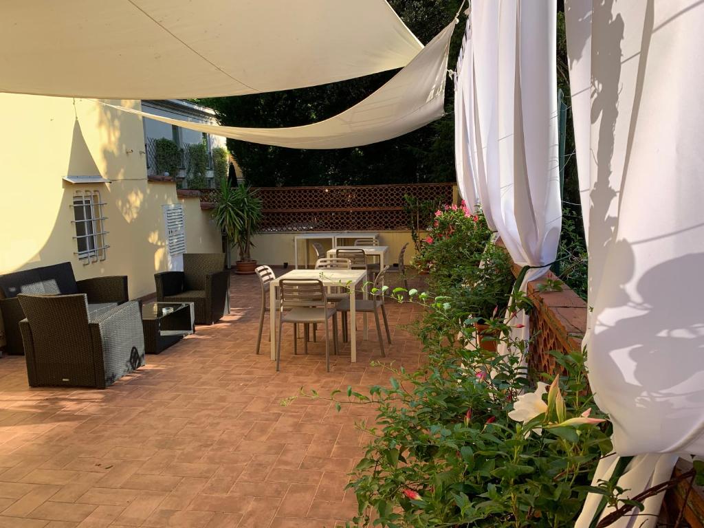 patio con tavolo, sedie e ombrellone di La Terrazza di via Elisa a Lucca