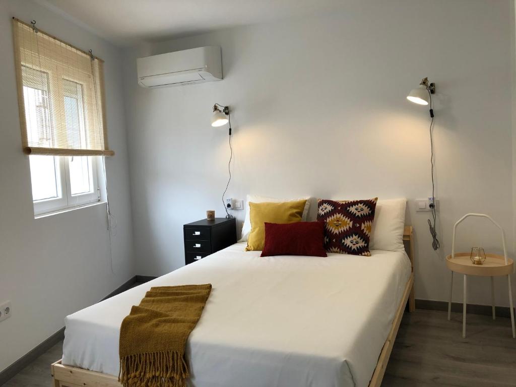 a bedroom with a large white bed with pillows at El Nidito de Lara in Santiago de Compostela