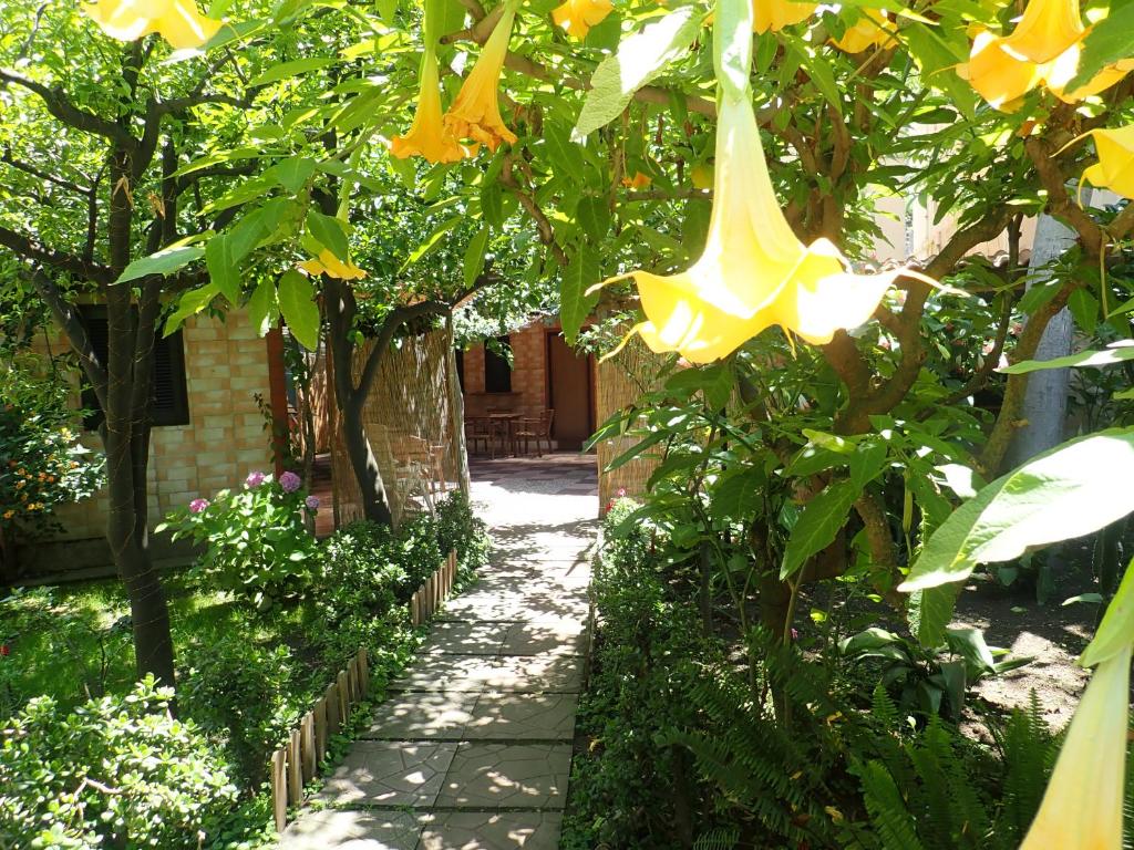 een loopbrug in een tuin met gele bloemen bij Capricornio Club in Maiori