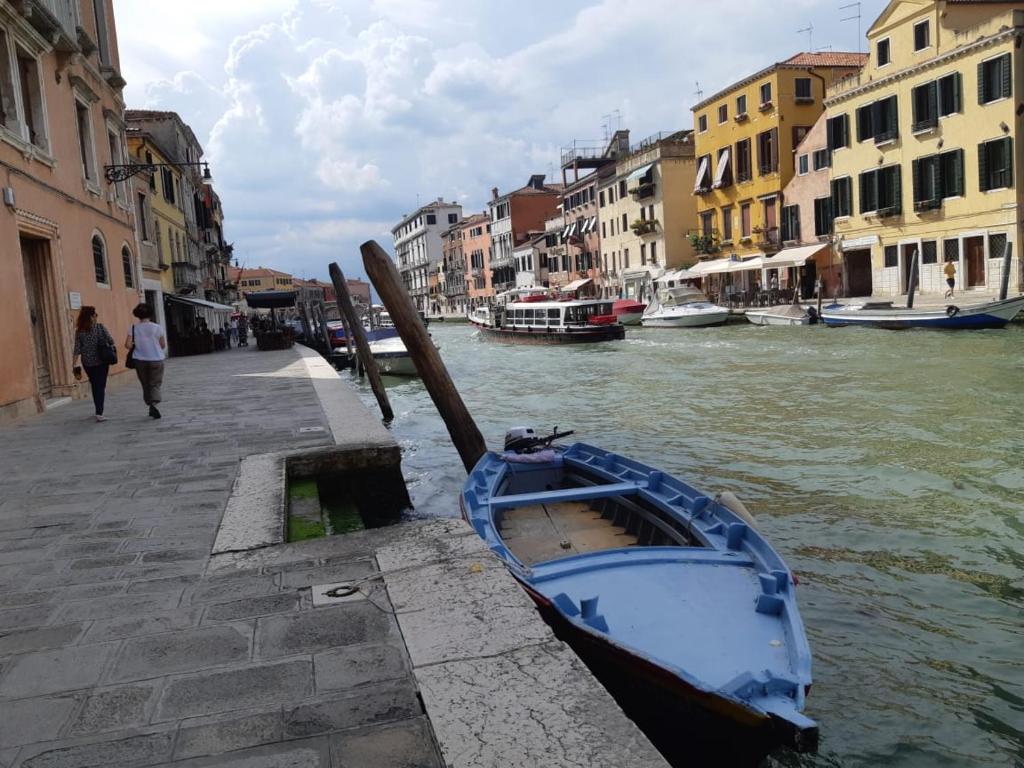 una barca blu seduta sul lato di un canale di Calle Rielo great canal view a Venezia