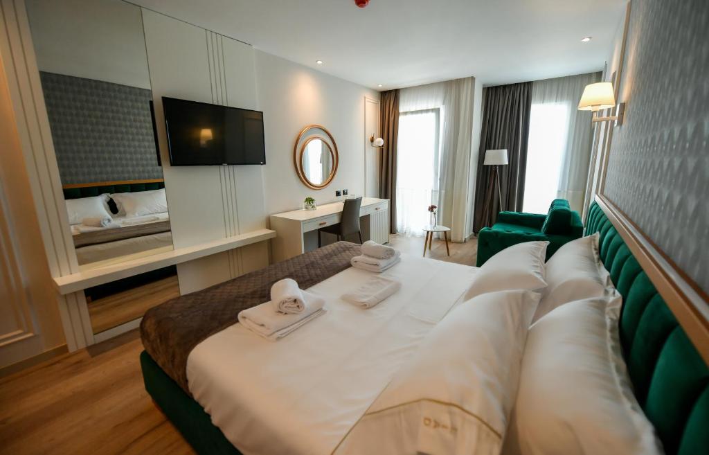 a hotel room with a bed with towels on it at Iliad Hotel in Durrës
