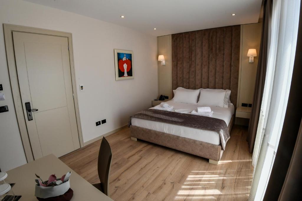 a hotel room with a bed and a table at Iliad Hotel in Durrës