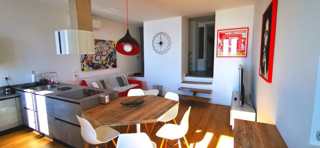 Il dispose d'une cuisine et d'un salon avec une table et des chaises en bois. dans l'établissement Magnifique Duplex vue Mer, à Menton