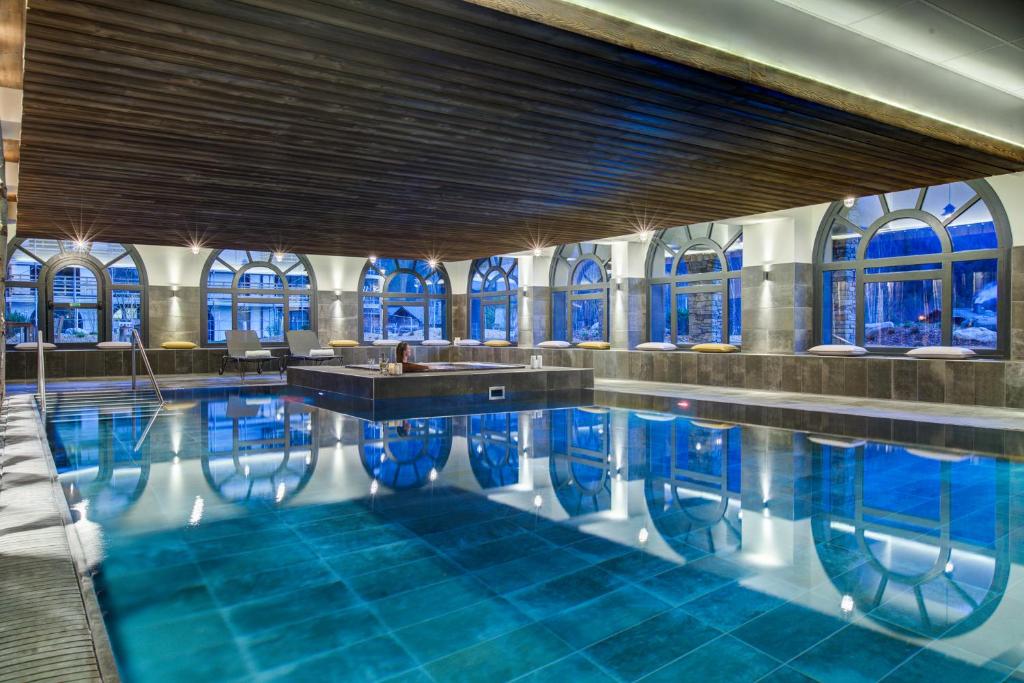 - une piscine dans un bâtiment doté de carreaux bleus dans l'établissement Résidence Luxe 5*,Spa & Fitness, La Cordée Appartement 214, à Chamonix-Mont-Blanc