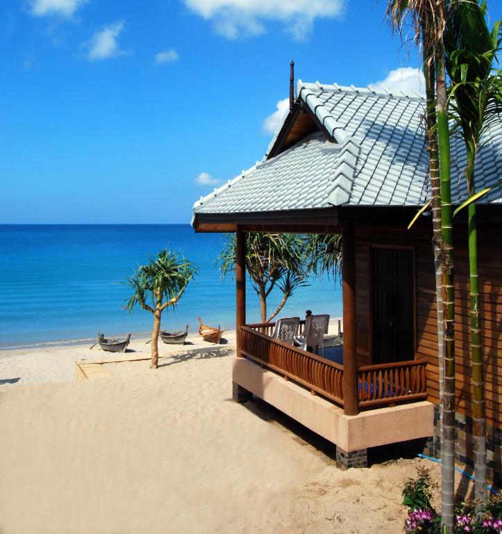 a building on the beach with the ocean in the background at Baan Pakgasri Hideaway in Ko Lanta