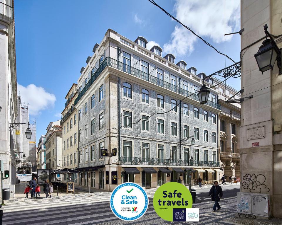 a large building on the corner of a city street at My Story Hotel Ouro in Lisbon