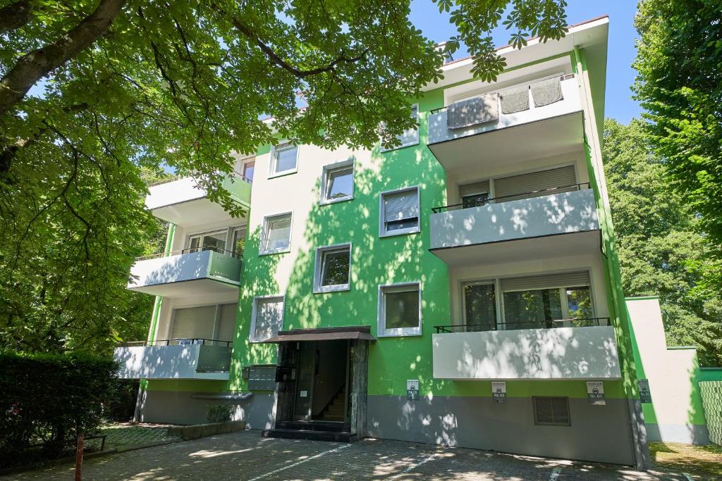 un immeuble d'appartements avec peinture verte dans l'établissement Boutique Apartments am Stadtgarten, à Fribourg-en-Brisgau