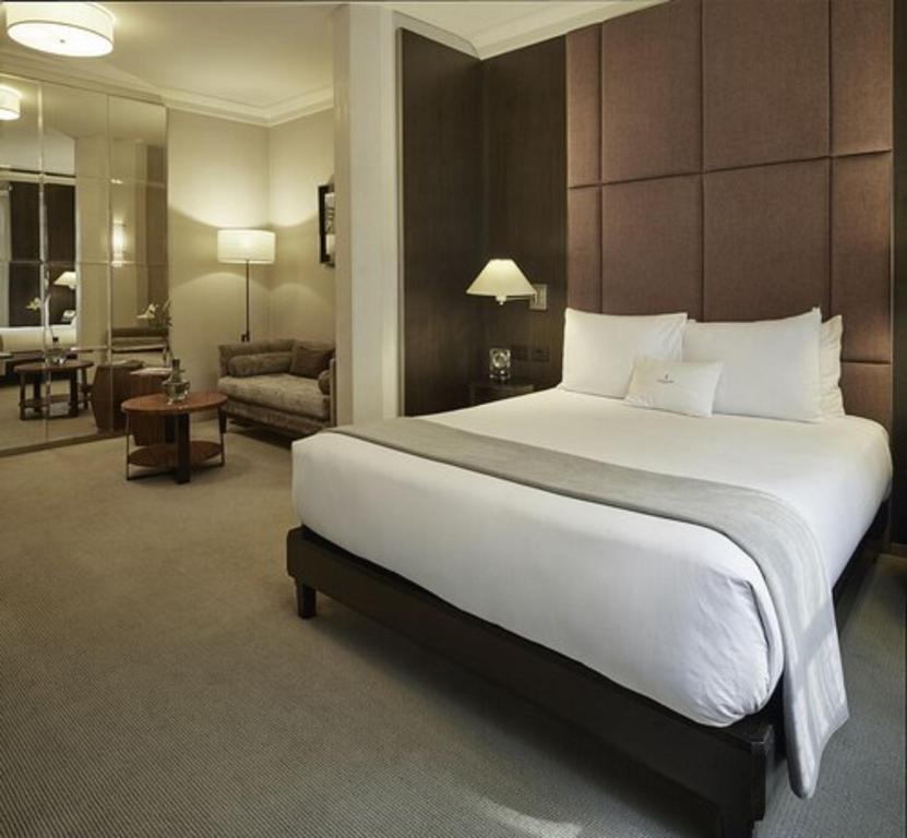 a bedroom with a large bed and a living room at Hippodrome Hotel Condesa in Mexico City
