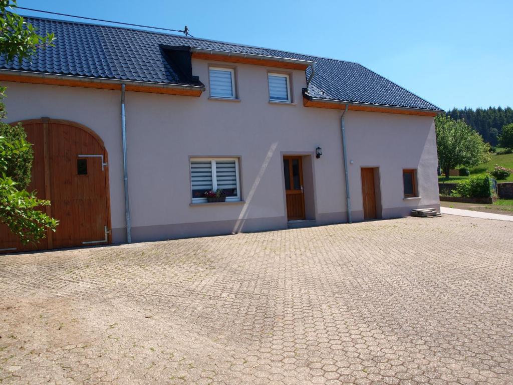 Uma casa branca com uma entrada à frente. em Haus Schritte em Hinterweiler