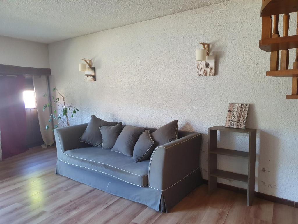 sala de estar con sofá azul y mesa en La Bergerie Crenantine en Crenans