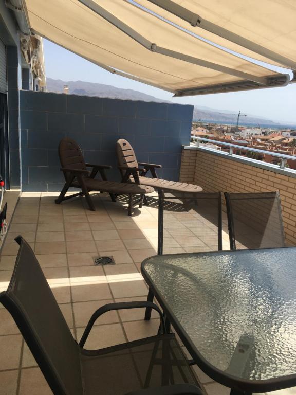 een balkon met een tafel en stoelen op een dak bij Las Salinas in Roquetas de Mar