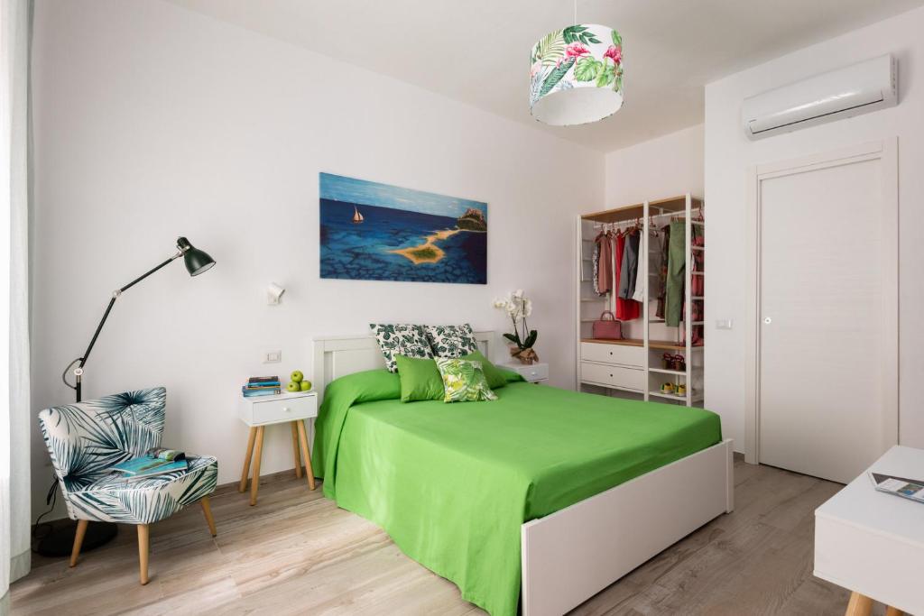 a bedroom with a green bed and a chair at Altré Guest House in Olbia
