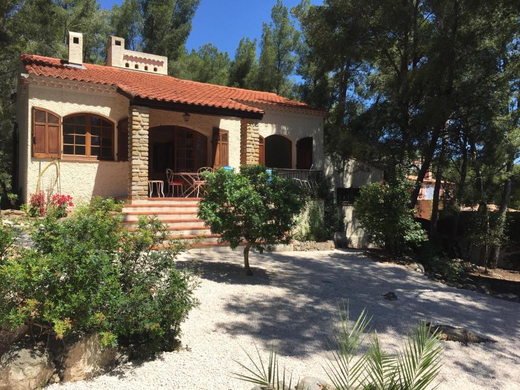 une petite maison dans une cour arborée dans l'établissement Villa provençale – grand jardin - 2 chambres, à Bandol