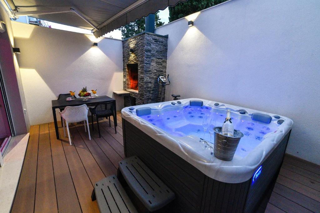 a jacuzzi tub on a deck with a table at Luxury Apartment Knezovic in Sinj