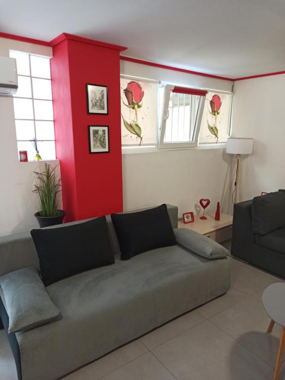 a living room with a couch and a red wall at casa al mare in Kavála