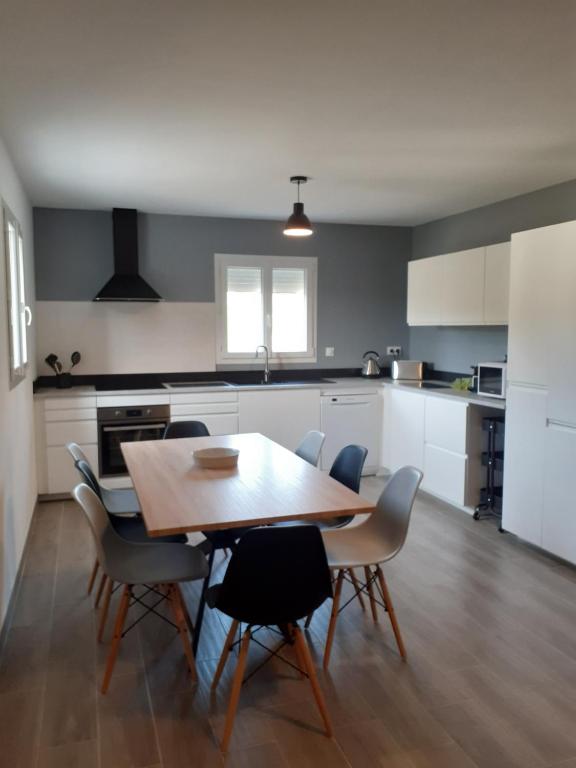 a kitchen with a wooden table and chairs at Evadorie in Le Barroux