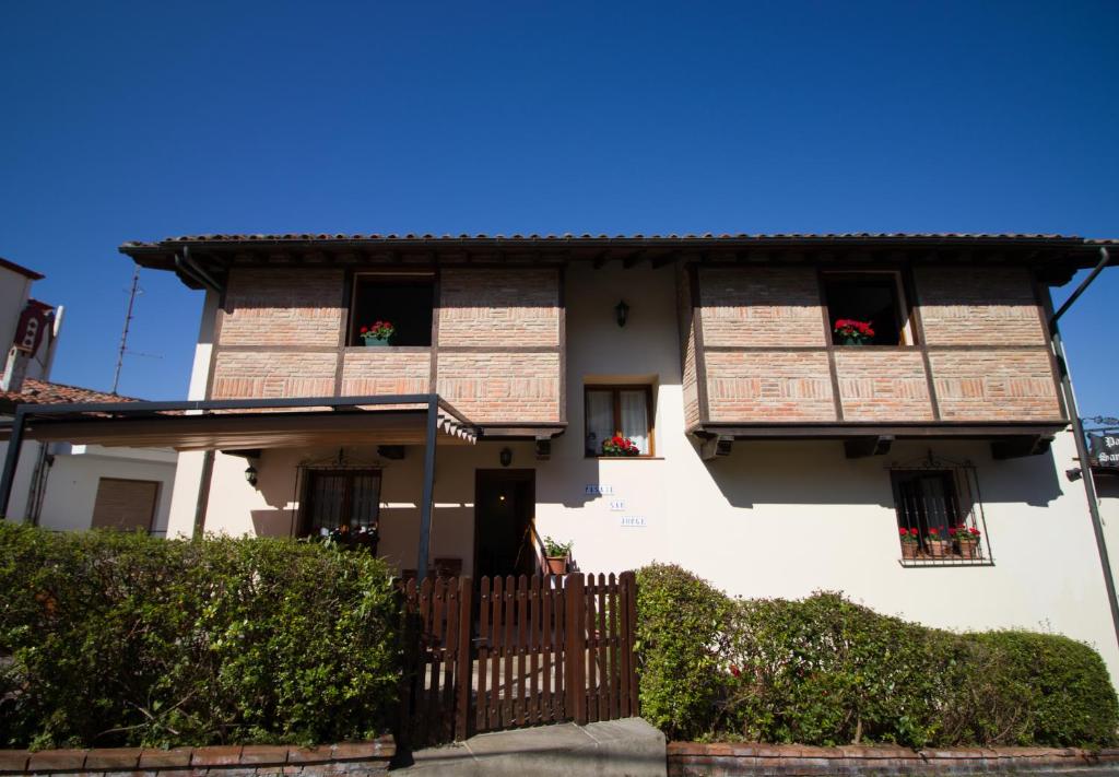 Casa blanca con ventanas y valla de madera en Pasaje San Jorge, en Comillas