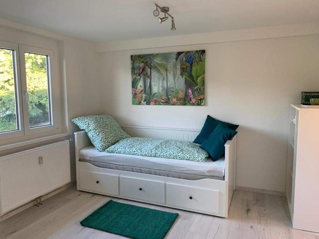 ein Zimmer mit einer Bank mit einem Gemälde an der Wand in der Unterkunft Greenhome in Weil am Rhein