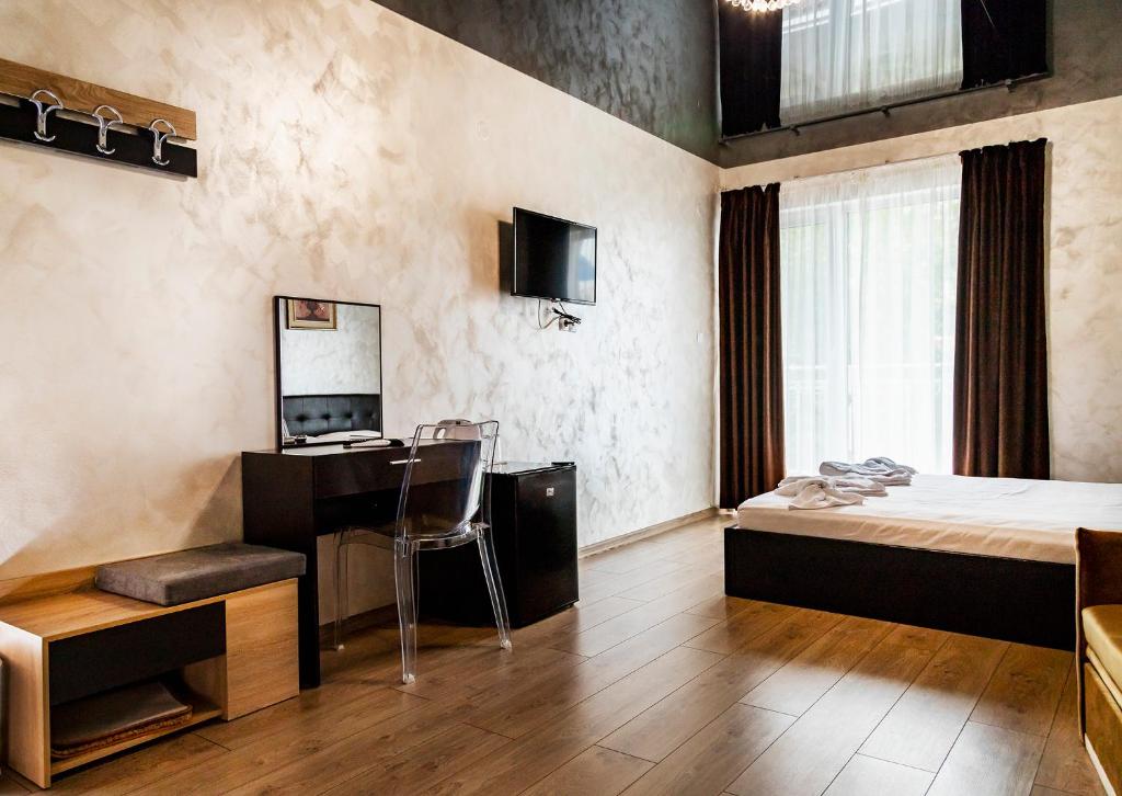 a hotel room with a bed and a desk and a bedroom at family hotel - City hotel yambol in Yambol