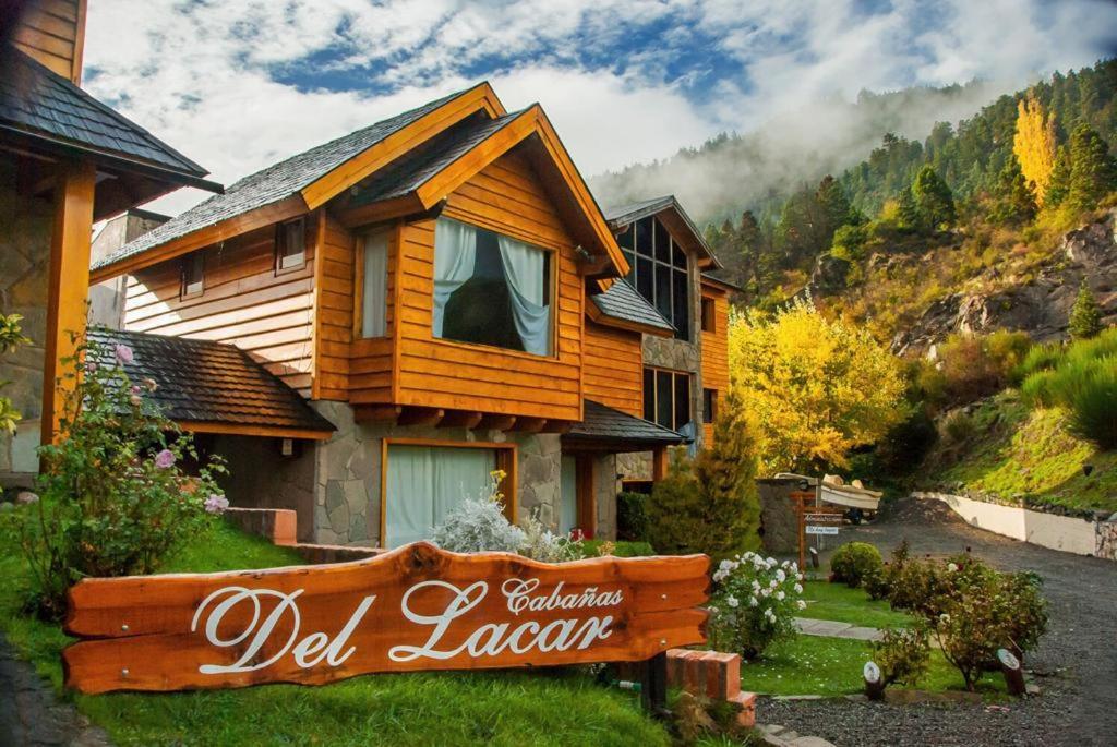una casa de madera con un cartel delante en Cabañas Del Lacar en San Martín de los Andes