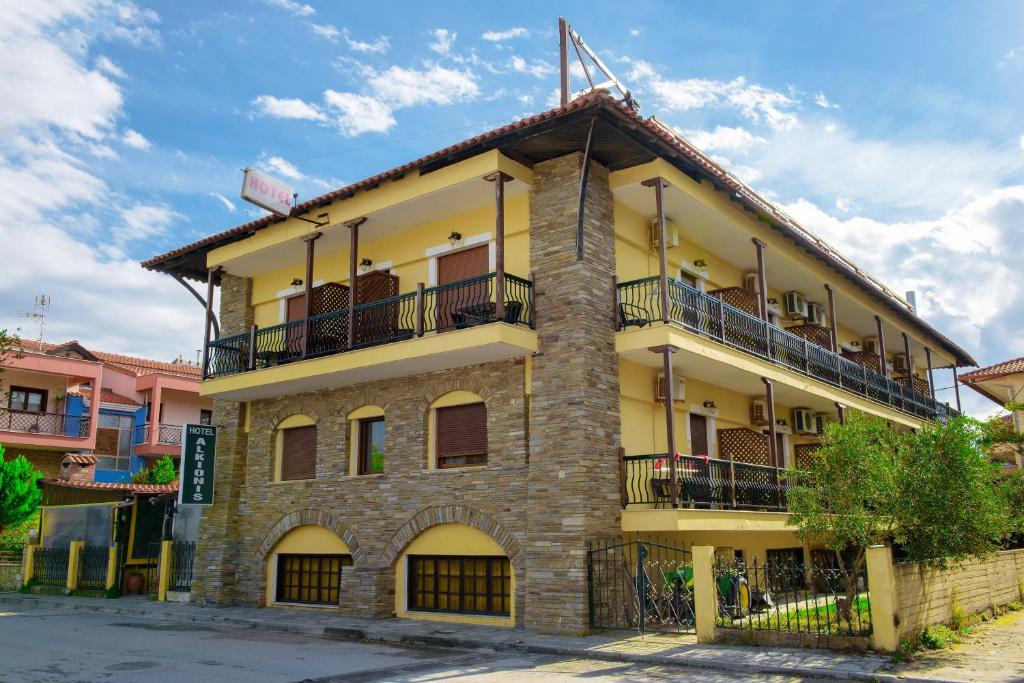 un edificio amarillo con balcones en una calle en Hotel Alkionis en Ierissos