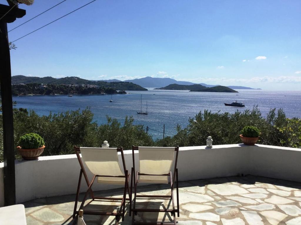 2 sedie su un balcone con vista sull'acqua di Golden View Villa a Città di Skiathos