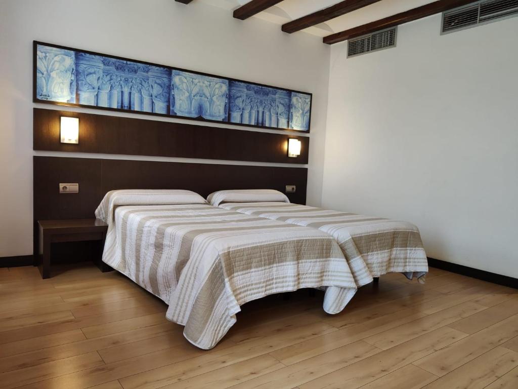 Un dormitorio con una cama con una manta. en Hotel Rey Sancho, en Navarrete