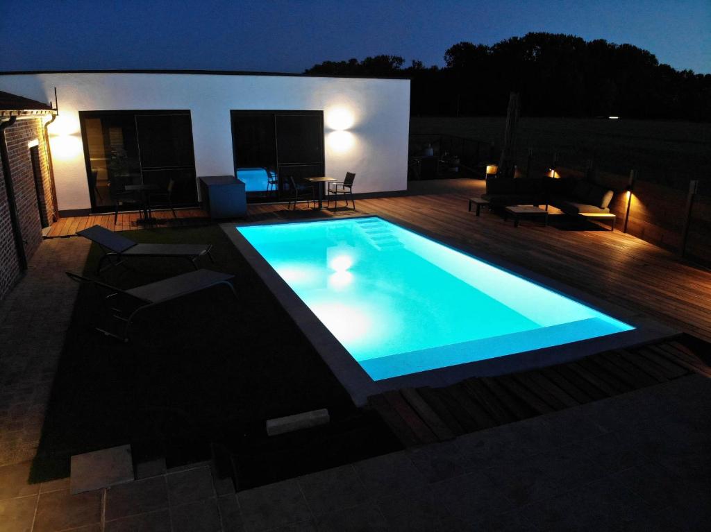 una piscina in un cortile posteriore di notte di B&B Presende a Veurne