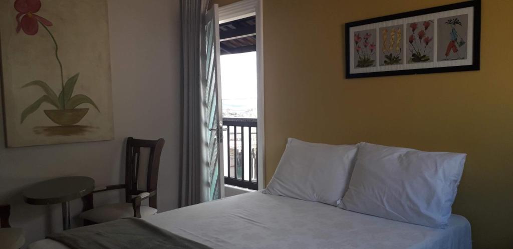 a bedroom with a bed and a window with a balcony at Tapindaré Hotel in Alto Paraíso de Goiás