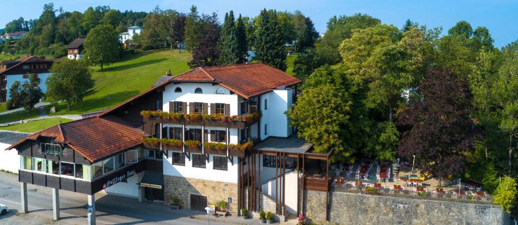 Elle offre une vue aérienne sur un grand bâtiment blanc doté d'un balcon. dans l'établissement Landhotel Gottinger, à Waldkirchen