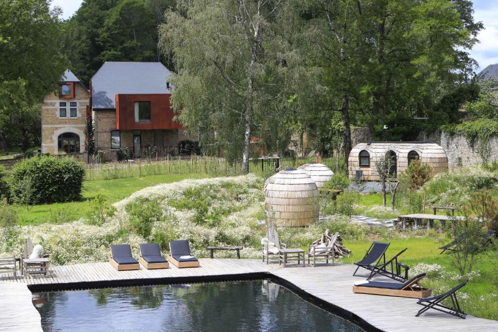 a swimming pool with lounge chairs and a house at Domaine de Ronchinne - Insolites in Maillen