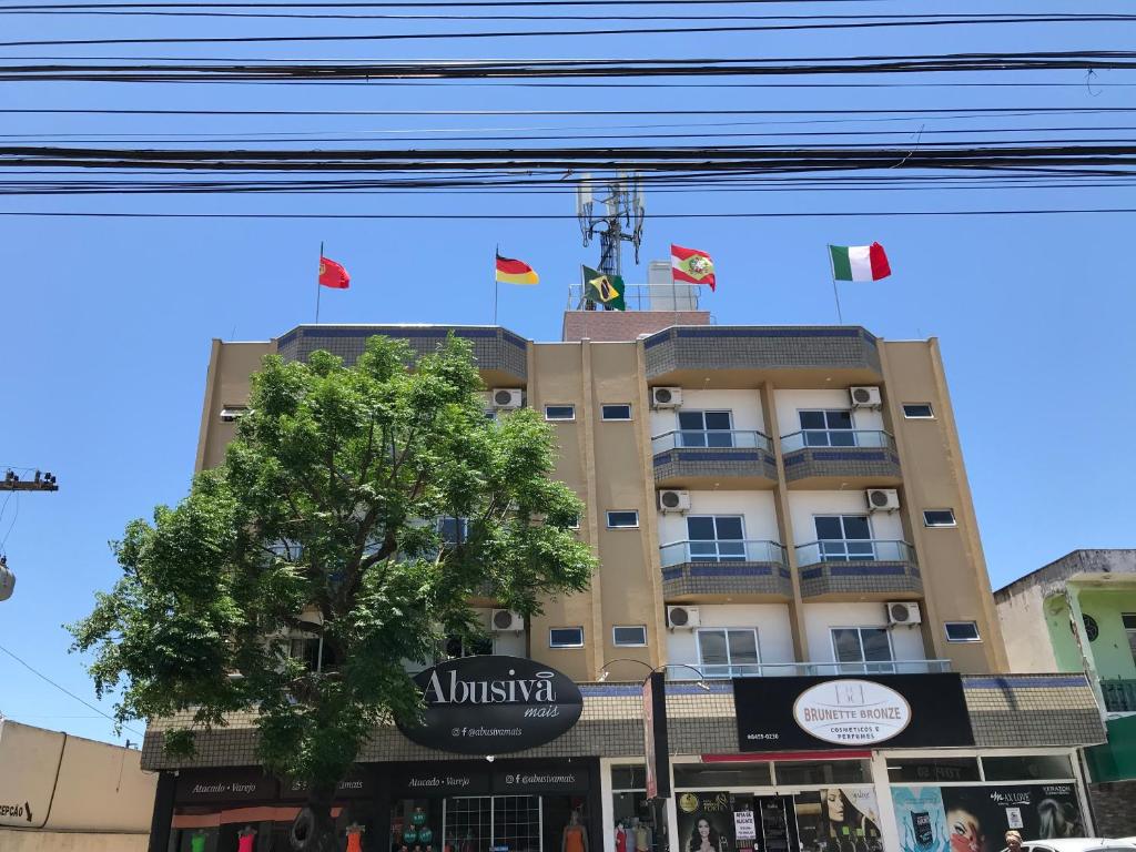 un edificio con banderas encima en Hotel Pontal, en Palhoça