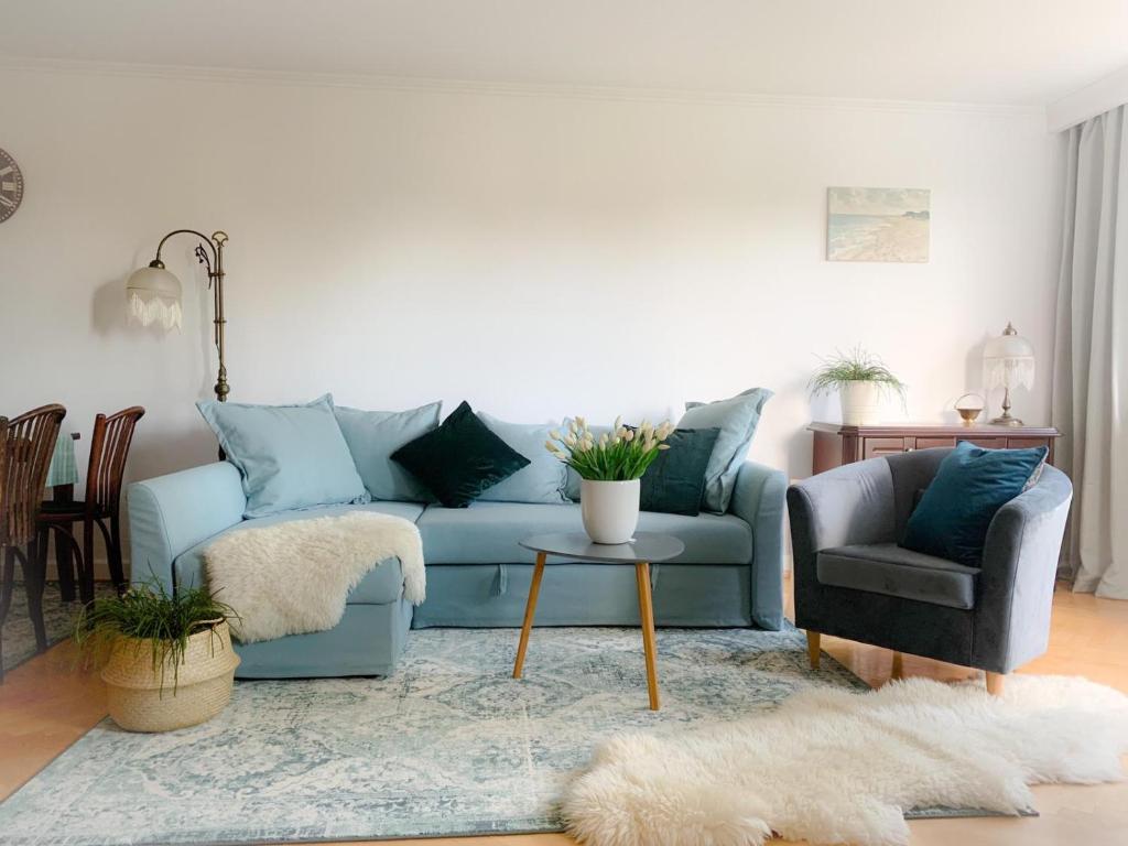 a living room with a blue couch and a chair at Apartament Grunwaldzka in Sopot