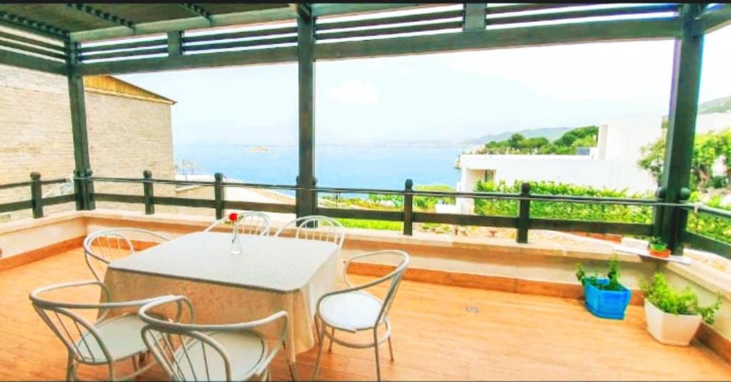 um pátio com uma mesa e cadeiras numa varanda em Aneta's Beach House em Vlorë