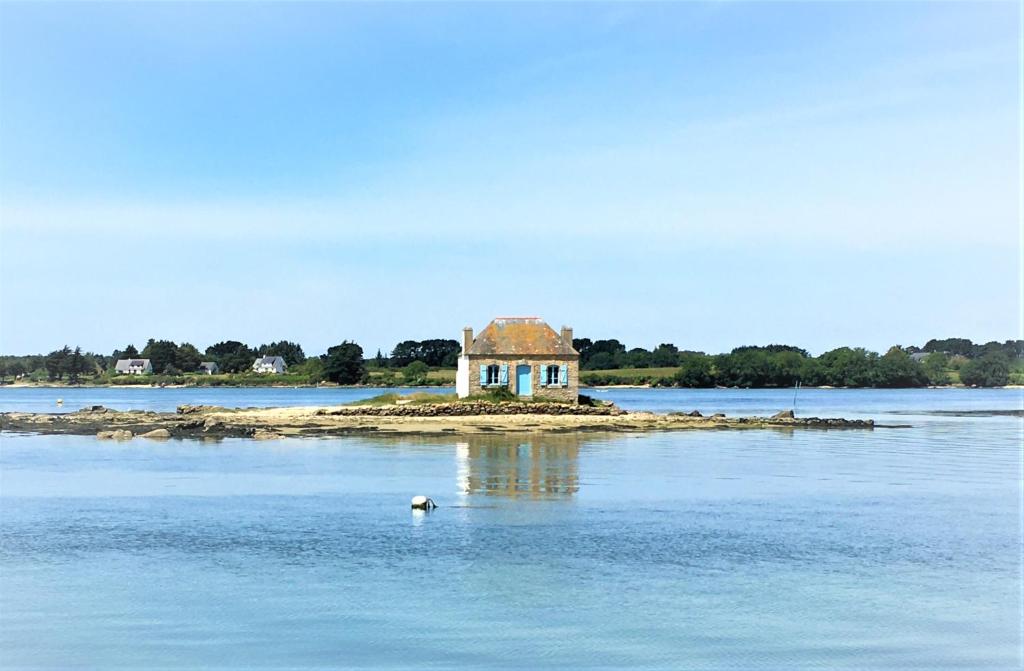 una isla con una casa en medio del agua en Pierre et mer au cœur de Saint Cado, en Belz