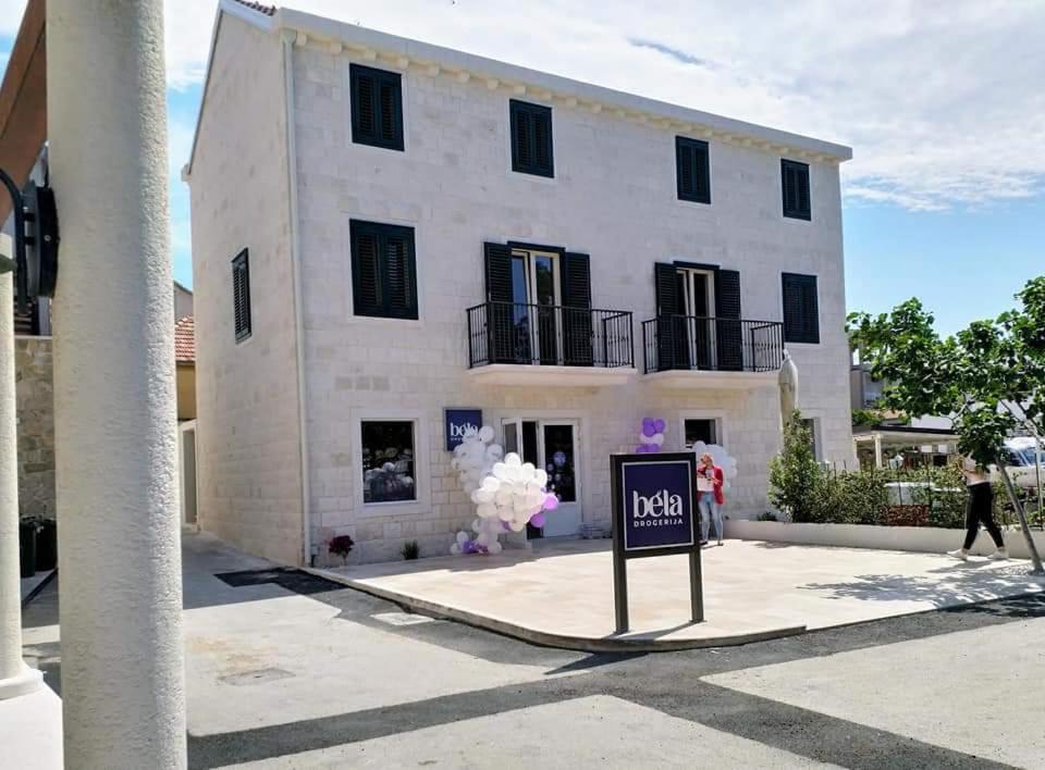 a large white building with a sign in front of it at Villa Bela in Primošten